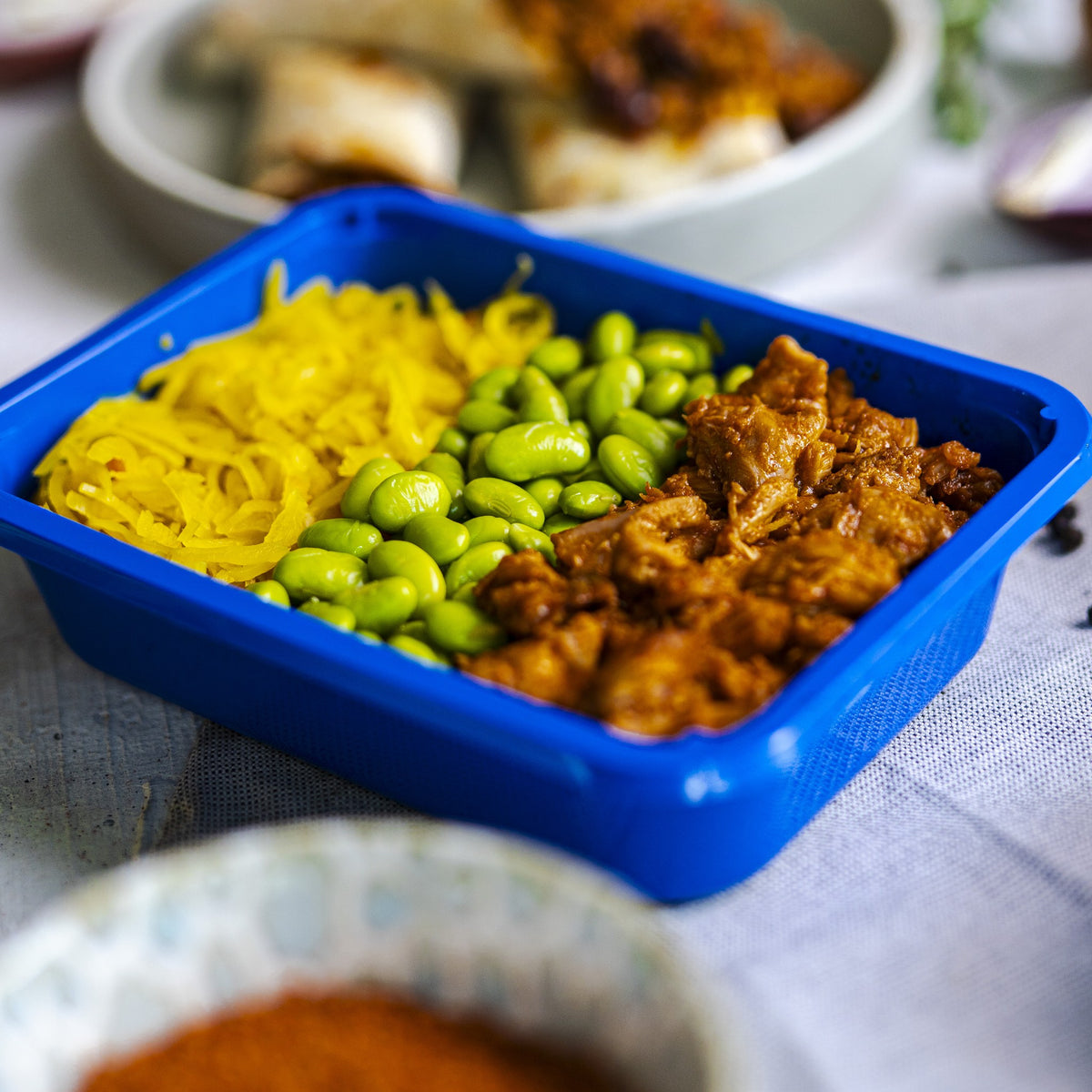 Kip Koreaans met atjar en sojabonen van SportMeals in het blauwe bakje, op tafel