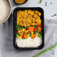 Kant-en-klare meal prep maaltijd met kip kerrie en mexicaanse gemengde groente voor tijdens het droogtrainen