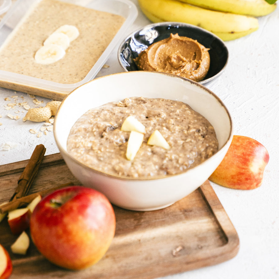 SportMeals apple-cinnamon overnight oats in a bowl, with fresh apple and cinnamon