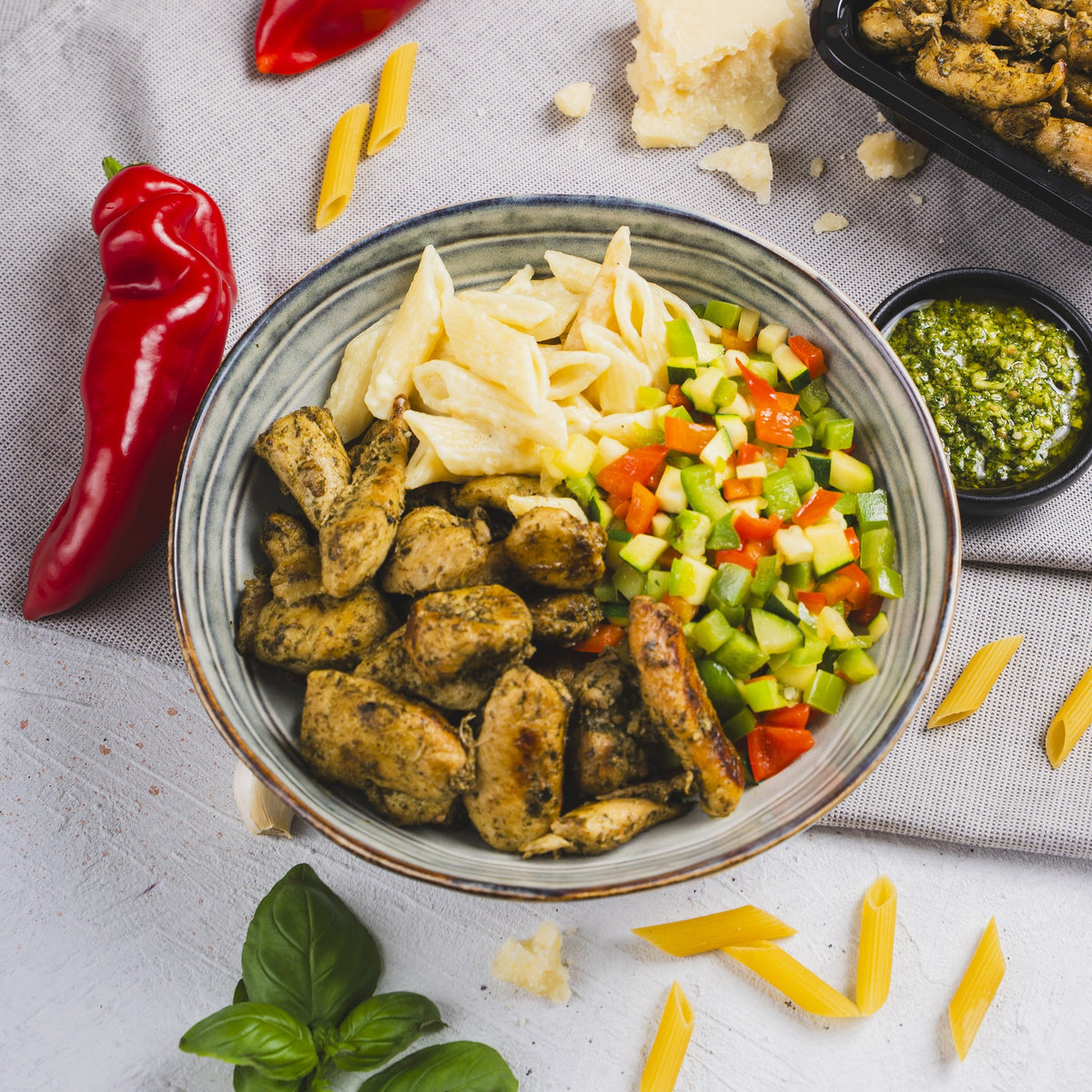 Pasta Chicken Pesto from SportMeals in a bowl, with fresh pepper, pesto and basil

Wait — "paprika" here means bell pepper. Final:

Pasta Chicken Pesto from SportMeals in a bowl, with fresh bell pepper, pesto and basil