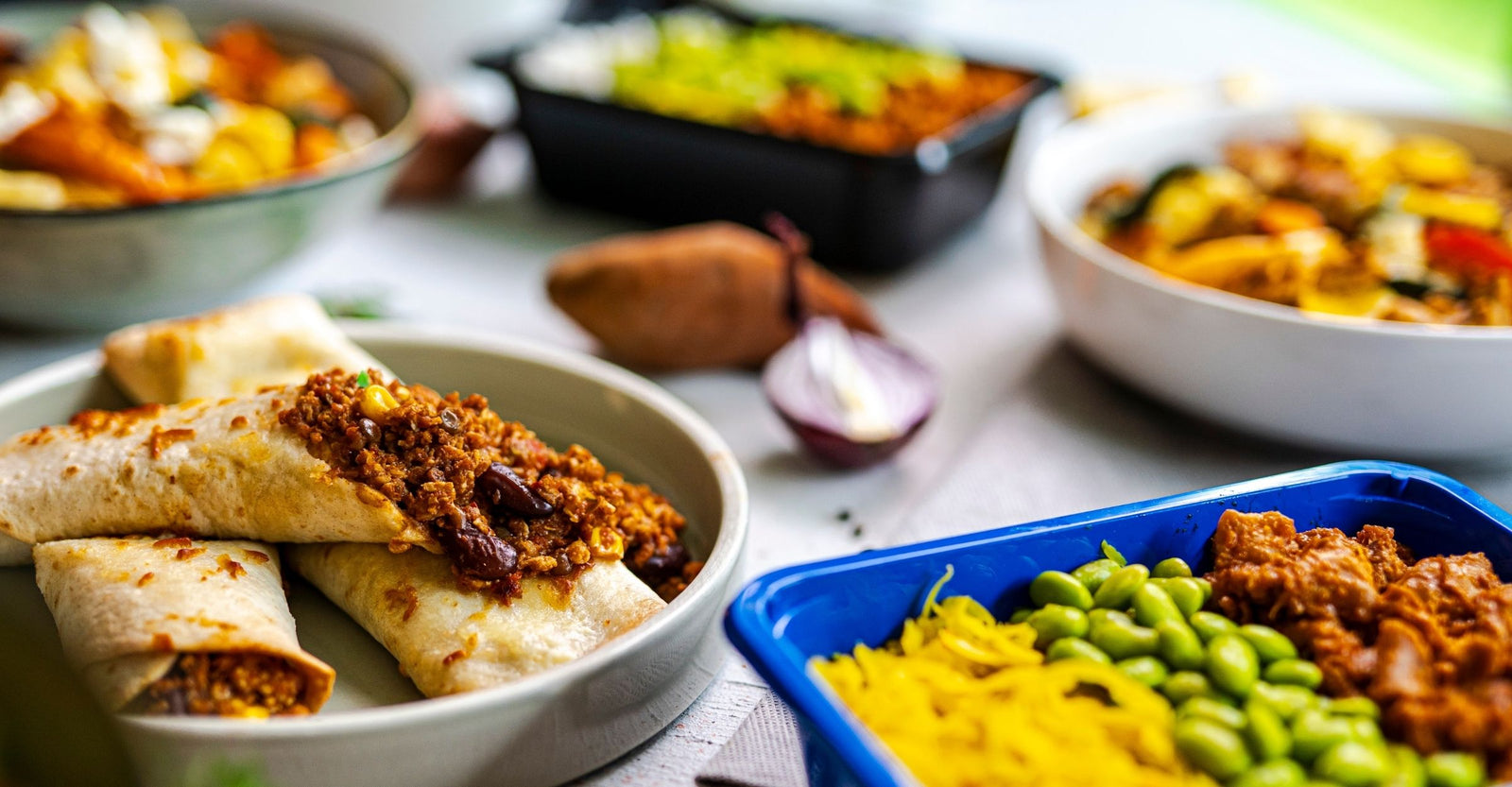 Zeven verschillende SportMeals-gerechten naast elkaar op tafel