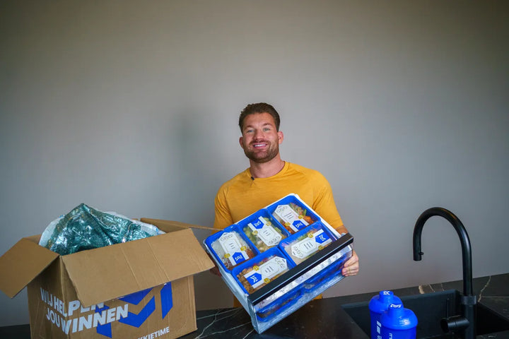 Joey toont een vriezerlade vol SportMeals-bakjes naast de doos