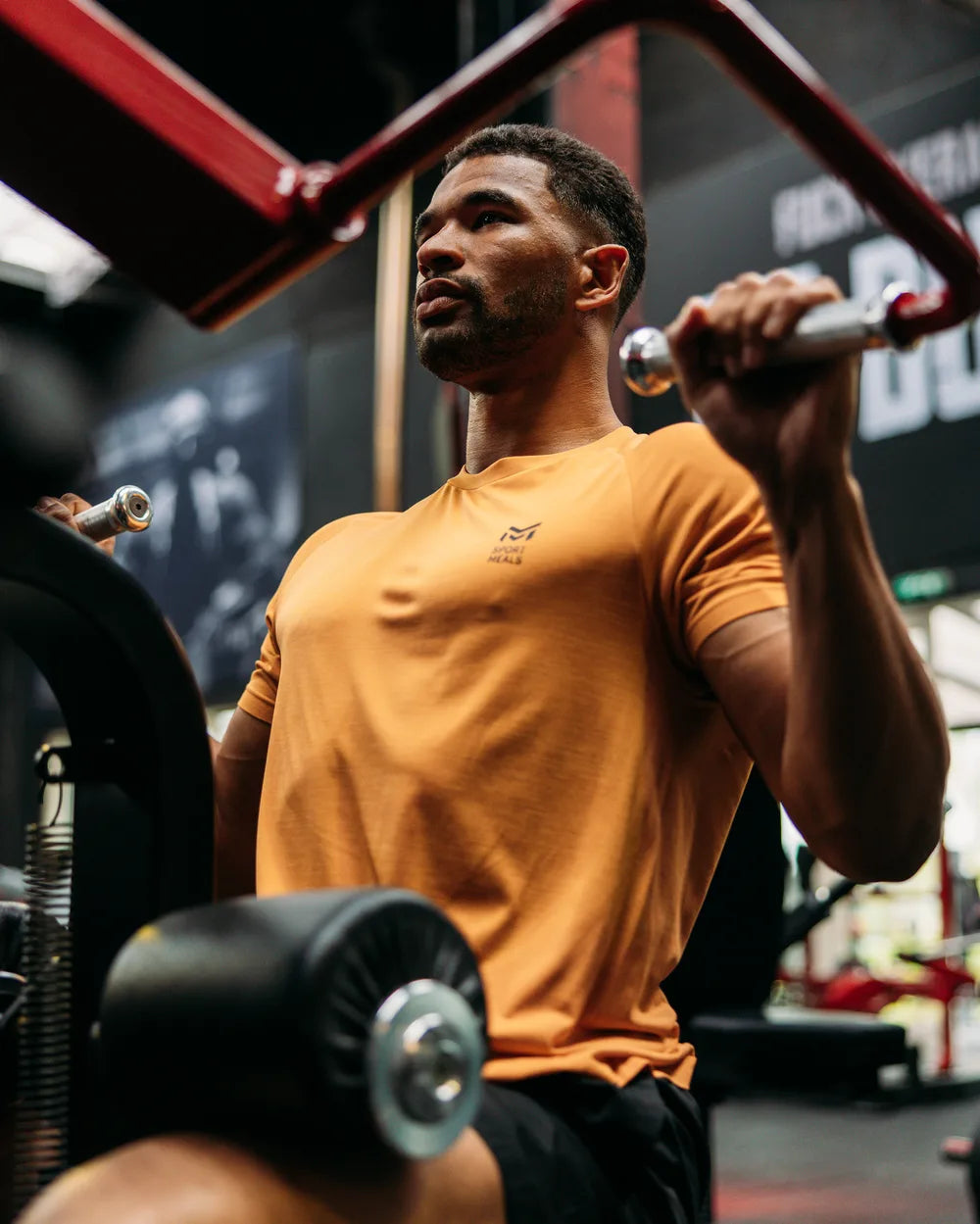 An athlete trains with focus on a strength machine in the gym