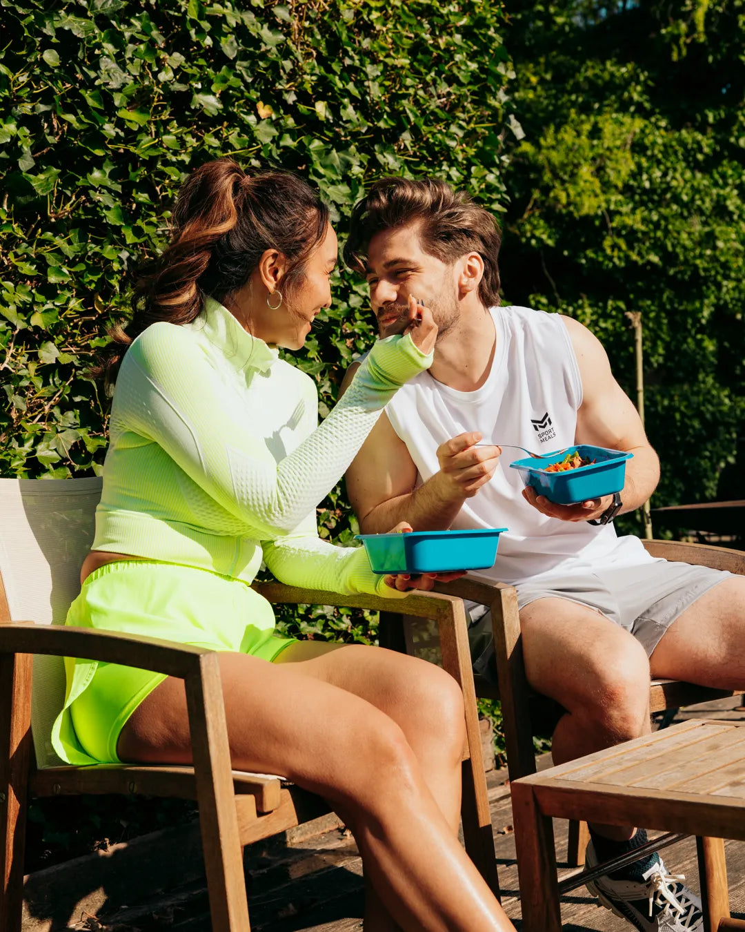 Robbin en Succi eten buiten samen uit blauwe SportMeals-bakjes