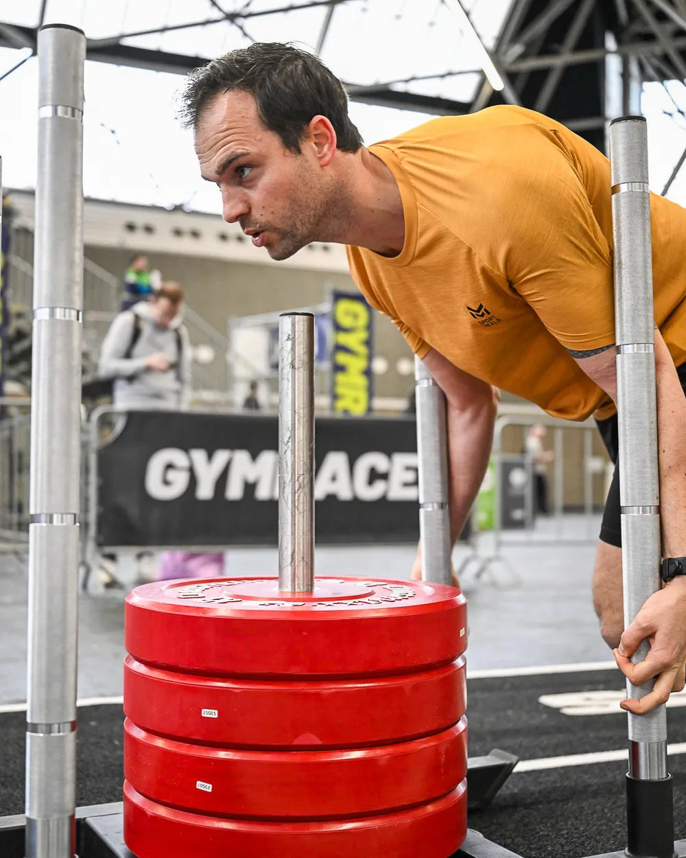 Een deelnemer duwt een sled met gewichten tijdens de Gym Race
