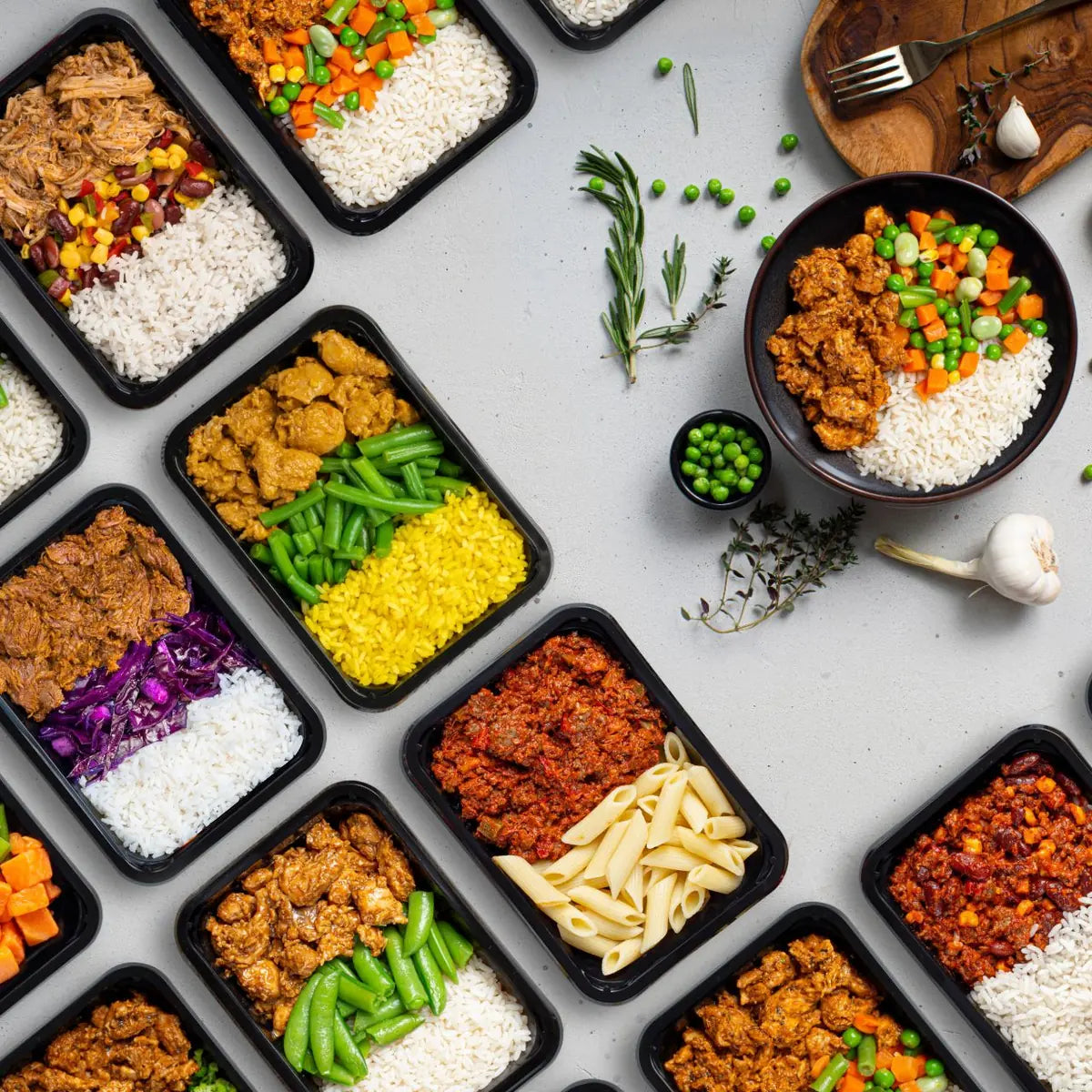Veertien SportMeals-maaltijden van 425 gram in zwarte bakjes, naast elkaar gefotografeerd